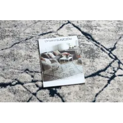 Alfombra moderna REBEC en tonos crema y azul oscuro, ideal para interiores contemporáneos