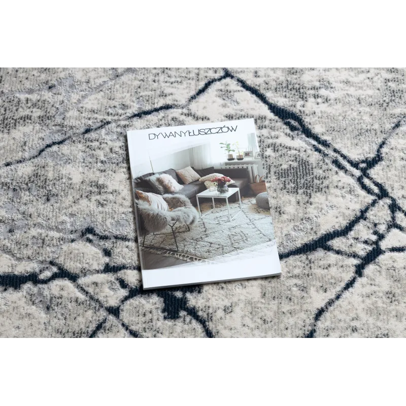 Alfombra moderna REBEC en tonos crema y azul oscuro, ideal para interiores contemporáneos